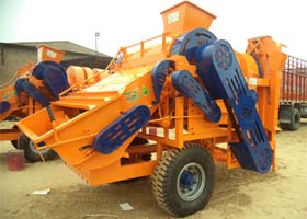 Close-up of a multicrop thresher machine showing the drum and grain separation mechanism with wheat and rice kernels visible